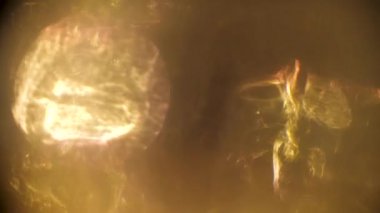 Soyut altın ışık darbeleri ve karanlık bir arka plan üzerinde parlar