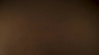 Altın ışık siyah bir arka plan üzerinde soyut etkisi sızdırıyor