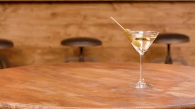 Boş bir ahşap masada martini bir bardak doğru kayma
