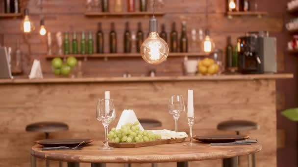 An empty table in an restaurant with cheese and grapes on — Stock Video