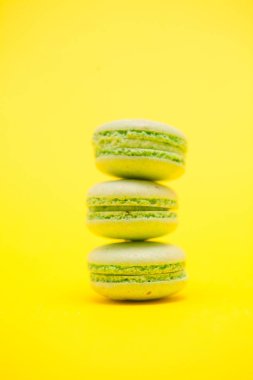 Sarı arka plan üzerinde Fransız renkli yeşil macaroons