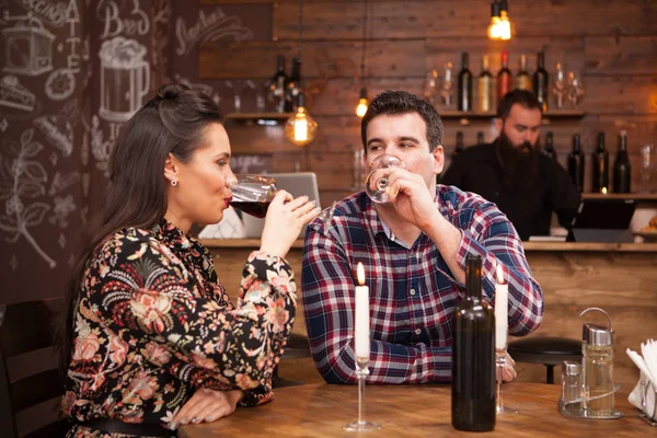 Casal beber vinho tinto e compartilhar um belo momento em um pub hipster . — Fotografia de Stock