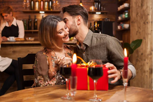 Attraktiver bärtiger Mann küsst seine Freundin auf die Wange, nachdem er ein Geburtstagsgeschenk erhalten hat — Stockfoto