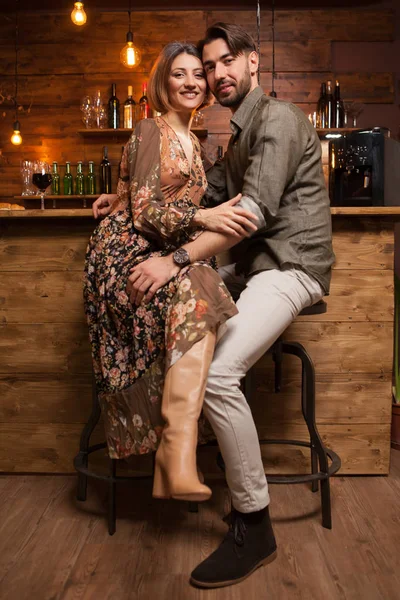 Beautiful young couple sitting at the counter and smiling to the camera — Stock Photo, Image