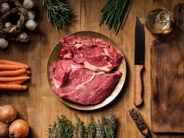 Ahşap masada farklı sebzeler ile vintage tabakta kırmızı et Taze parçalar