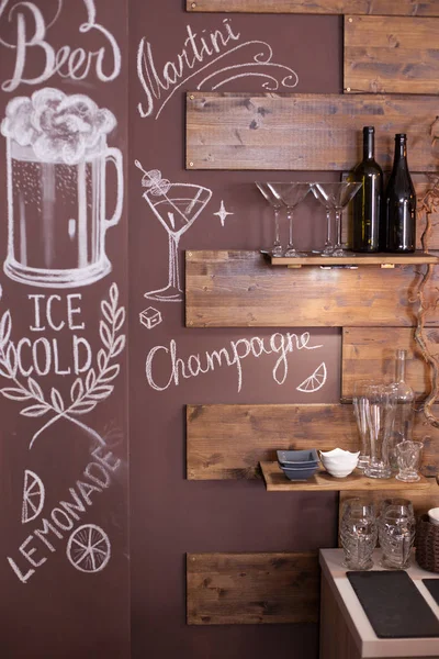 Бокал мартини, нарисованный на стене винтажной кофейни рядом с винной полкой — стоковое фото