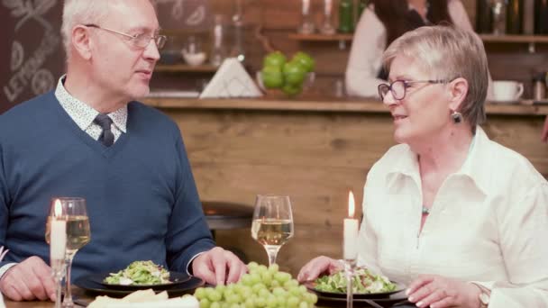 Stary człowiek oferuje trzy czerwone róże do żony na romantyczną kolację — Wideo stockowe