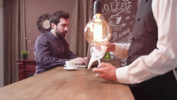 Jeune homme à un comptoir de bar tapant passionnément un texte sur son ordinateur portable — Video