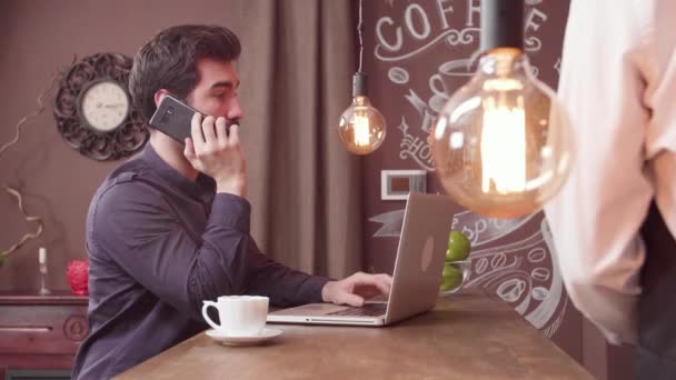 Bir bar tezgahında çalışırken akıllı telefon adam görüşmeler — Stok video