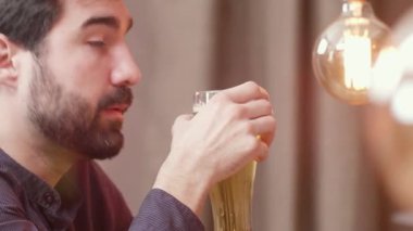 Yakışıklı sakallı adam bira içer ve barmen konuşur