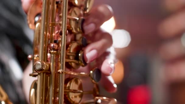 Primer plano de dedos de mujer tocando una composición en un saxofón — Vídeo de stock