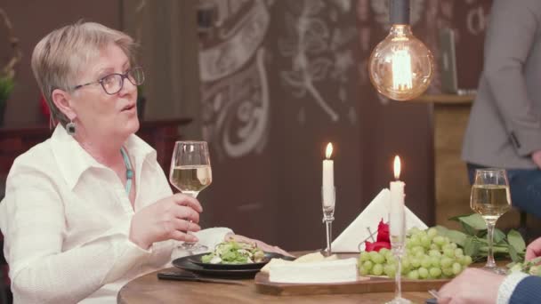 Reife Dame klirrt Brille mit ihrem Partner — Stockvideo