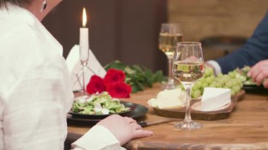 Şarap ve yemek içen olgun erkek ve kadın ellerinin yakın çekim