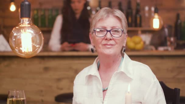 Retrato de uma bela senhora sentada em uma mesa em um bar — Vídeo de Stock