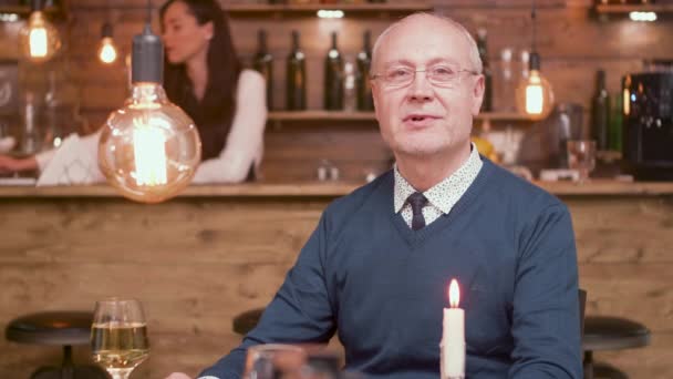 Ritratto di un bell'uomo anziano che parla con la telecamera in un bar — Video Stock