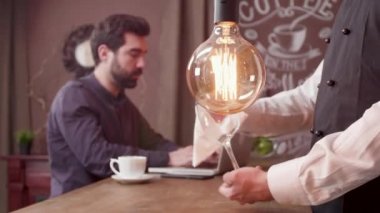 Barmen bir müşteri bar tezgahında çalışırken bir bardak temizleme