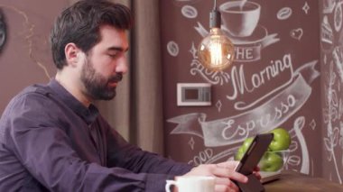 Sakallı genç adam görüntülü sohbet için tabletini kullanıyor