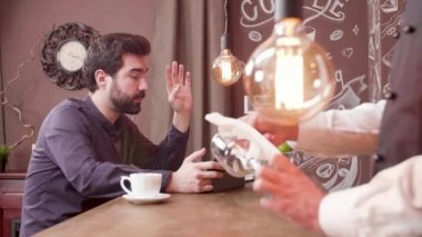 Bir kafede yken tabletinde video konferans olan adam
