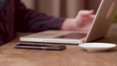 Adam kahve içer ve parasını ödemek için akıllı telefonunu kullanır.
