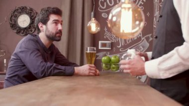 Adam gülüyor ve bir bardak bira içerken eğleniyor