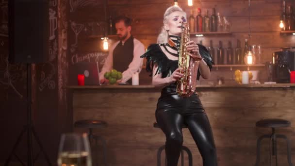 Krásná žena se stylovými černými šaty hraje na saxofon — Stock video