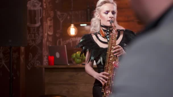 Blonde vrouwelijke muzikant hartstochtelijk het uitvoeren van een lied op een saxofoon — Stockvideo