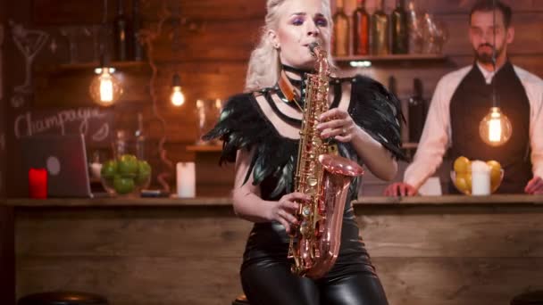 Mulher executa em um saxofone na frente de um balcão de bar — Vídeo de Stock