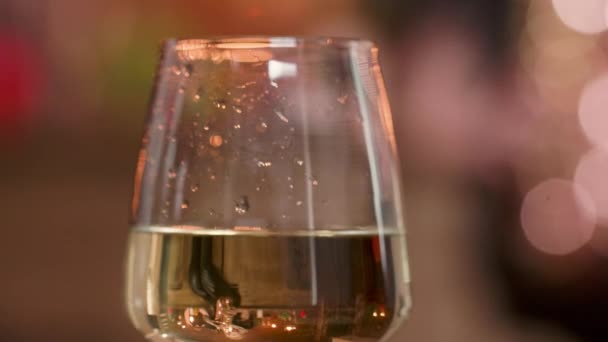 Kvinnlig hand som håller ett glas vitt vin på en levande saxofon prestanda — Stockvideo