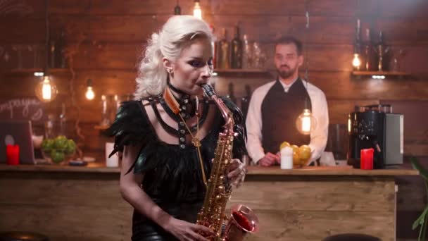 Blond female musician plays virtuously on a saxophone — Stock Video