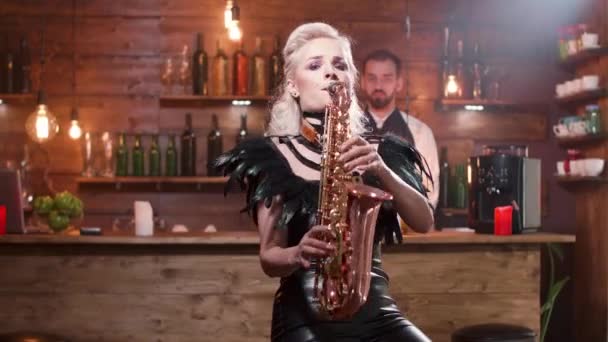 Jolie femme en costume de scène noir jouant une mélodie sur saxophone — Video