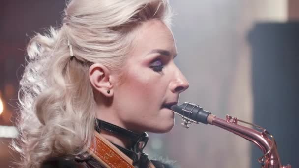 Retrato de cerca de una músico cantando una canción en un saxofón — Vídeo de stock