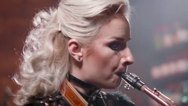 Retrato de cerca de una músico tocando virtuosamente en un saxofón — Vídeo de stock