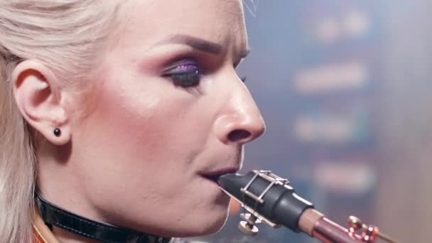 Retrato de cerca extremo de una músico cantando una canción en un saxofón — Vídeo de stock