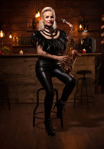 Belle jeune femme jouant sur saxophone dans un pub vintage — Photo