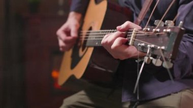 Mans eller bir akustik gitar tutarak ve bir kompozisyon performans