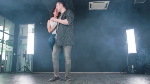 A man and a sensual woman dancing kizomba in a dance studio — Stock Video