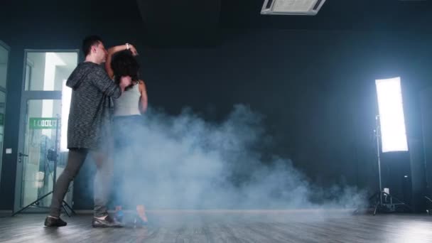 漂亮的夫妇在舞蹈工作室的黑色背景前跳舞 — 图库视频影像