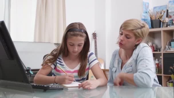 Девочка-подросток рисует что-то в блокноте, и мать разговаривает с ней. — стоковое видео