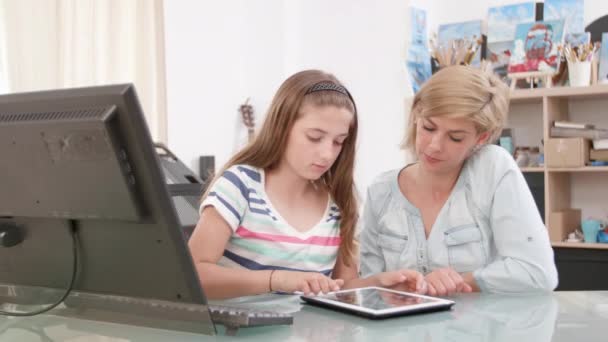 Nastoletnie dziewczyny przesuwając ekran tabletu, podczas gdy jej matka patrzy na ekranie — Wideo stockowe