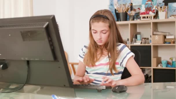 Νεαρή κοπέλα πληκτρολογεί ένα κείμενο σε ένα πληκτρολόγιο και χρησιμοποιεί το ποντίκι — Αρχείο Βίντεο