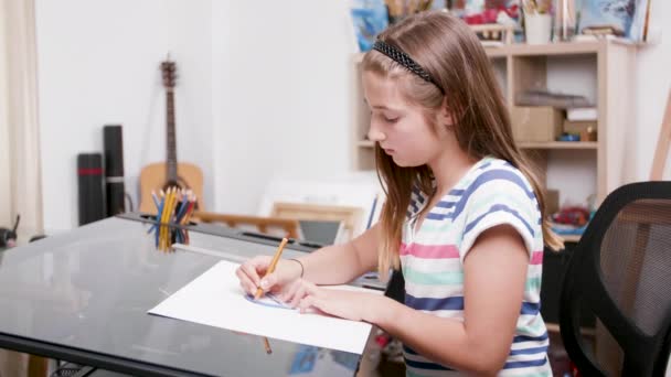 Молода дівчина малює кілька ліній за допомогою олівця і проектора — стокове відео
