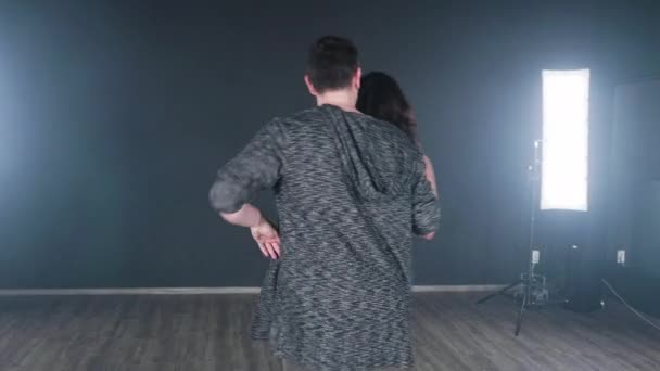 Hombre con una mujer más joven practicando en un estudio de danza — Vídeos de Stock