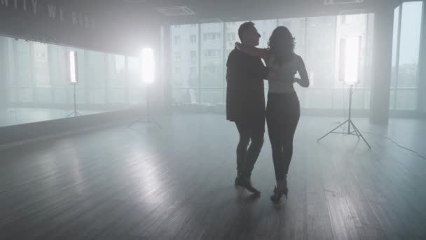 Hombre guapo bailando con su novia en un estudio de baile — Vídeo de stock
