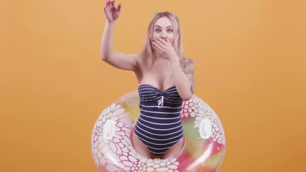 Блондинка с купальным кольцом, притворяющаяся ныряющей — стоковое видео
