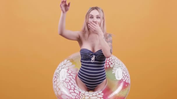 Jeune femme blonde avec un anneau de natation prétendant plonger 