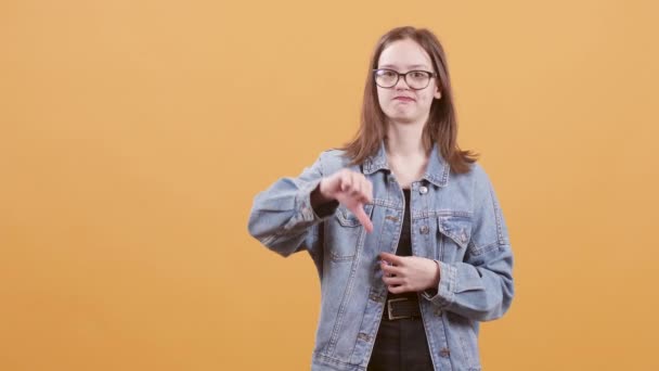 Дівчинка-підліток вказує на її великі пальці вниз не любить і бентежить — стокове відео