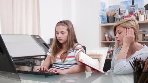 Anya diktálja a szöveget egy könyvet a lányát — Stock videók
