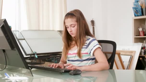 Jovem adolescente trabalhando em um computador e digita um texto — Vídeo de Stock