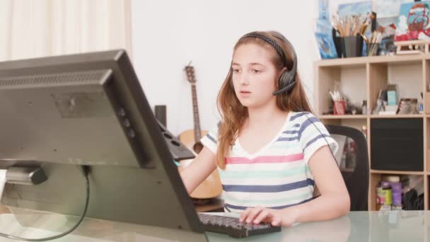 Menina jogando em seu computador um jogo online com seus amigos virtuais — Vídeo de Stock