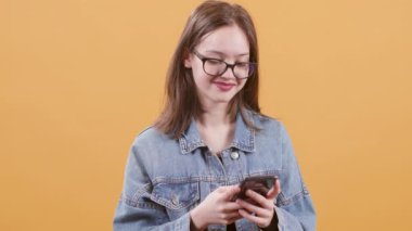 Sevimli genç kız onu akıllı telefon ekranına bakar ve gülümsüyor